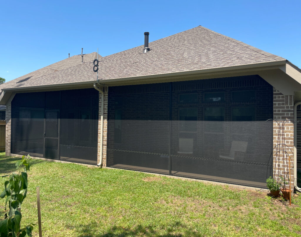 Sleek black patio screen installation on a brick home, designed by Metal Masons for elegant backyard lounging in Montgomery County.

