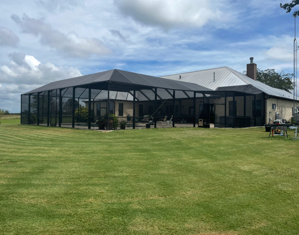 Large-scale screened pavilion for residential backyard use, installed by Metal Masons to offer full-property coverage and comfort.

