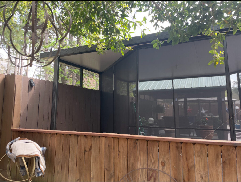 Contemporary privacy screen built by Metal Masons alongside a wooden fence, providing shade and seclusion for outdoor spaces.

