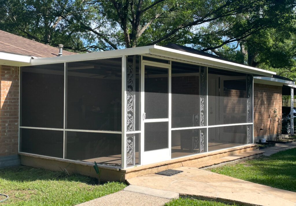 White frame screen porch enclosure with decorative trim, crafted by Metal Masons for classic Southern charm and year-round outdoor use.

